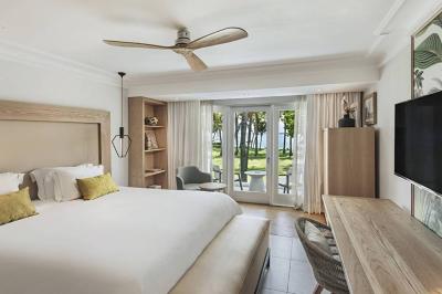 Miniature Location salle Flic-en-Flacq (District de Rivière Noire) - Hôtel Sugar Beach #20 Chambre lumineuse avec lit double, bureau, fauteuil, étagères en bois et vue sur une salle de bain ouverte.