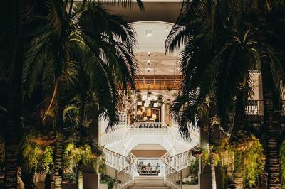 Miniature Location salle Flic-en-Flacq (District de Rivière Noire) - Hôtel Sugar Beach #6 Chambre lumineuse avec lit double, bureau, fauteuil, étagères en bois et vue sur une salle de bain ouverte.