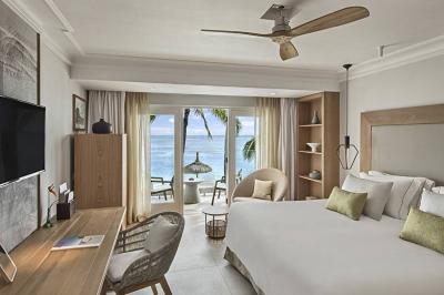 Miniature Location salle Flic-en-Flacq (District de Rivière Noire) - Hôtel Sugar Beach #21 Chambre lumineuse avec lit double, bureau, fauteuil, étagères en bois et vue sur une salle de bain ouverte.