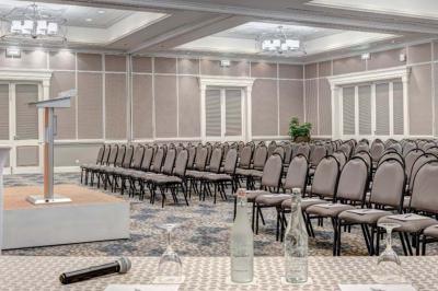 Miniature Location salle Flic-en-Flacq (District de Rivière Noire) - Hôtel Sugar Beach #2 Chambre lumineuse avec lit double, bureau, fauteuil, étagères en bois et vue sur une salle de bain ouverte.