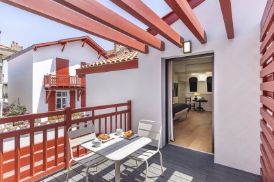 Lavabo moderne avec un distributeur de savon blanc et une serviette pliée dans une salle de bain lumineuse.
