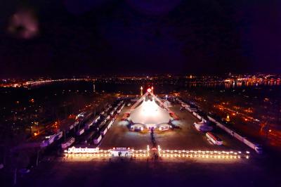 Personnes dansant sous des éclairages colorés dans une salle sombre avec des gradins en arrière-plan.