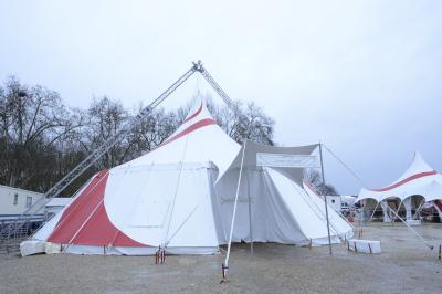 Salle de spectacle circulaire avec gradins éclairés par des lumières violettes et une scène centrale.