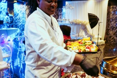 Buffet avec plats variés, incluant viandes grillées garnies de citron et légumes frais en présentation colorée.