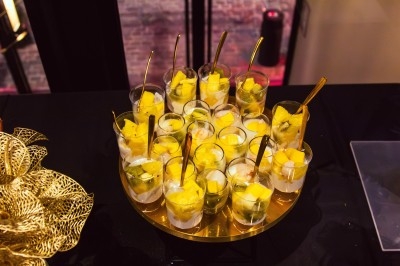 Buffet avec plats variés, incluant viandes grillées garnies de citron et légumes frais en présentation colorée.