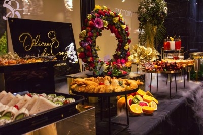 Buffet avec plats variés, incluant viandes grillées garnies de citron et légumes frais en présentation colorée.