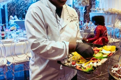 Buffet varié avec plats de viande grillée, légumes frais et charcuterie, présenté dans des plats en métal.