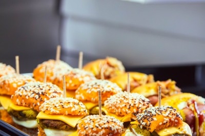 Buffet varié avec plats de viande grillée, légumes frais et charcuterie, présenté dans des plats en métal.