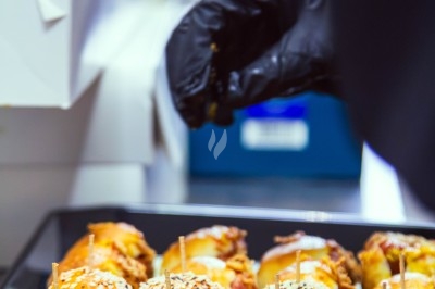 Buffet varié avec plats de viande grillée, légumes frais et charcuterie, présenté dans des plats en métal.