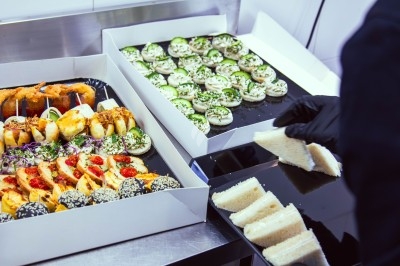 Buffet varié avec plats de viande grillée, légumes frais et charcuterie, présenté dans des plats en métal.