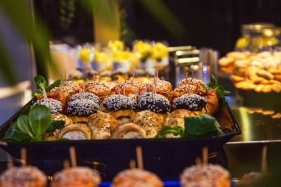 Buffet varié avec plats de viande grillée, légumes frais et charcuterie, présenté dans des plats en métal.