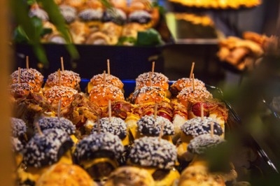 Buffet varié avec plats de viande grillée, légumes frais et charcuterie, présenté dans des plats en métal.