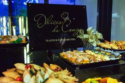 Buffet varié avec plats de viande grillée, légumes frais et charcuterie, présenté dans des plats en métal.