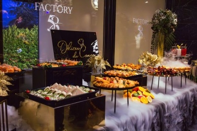 Buffet varié avec plats de viande grillée, légumes frais et charcuterie, présenté dans des plats en métal.