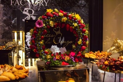 Buffet varié avec plats de viande grillée, légumes frais et charcuterie, présenté dans des plats en métal.