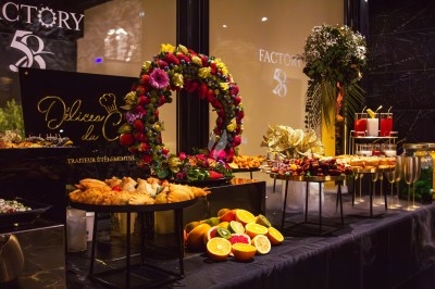 Buffet varié avec plats de viande grillée, légumes frais et charcuterie, présenté dans des plats en métal.