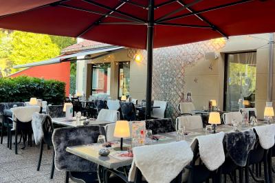 Cabane en bois enneigée avec un feu allumé à l'intérieur, vue de nuit dans un paysage hivernal.