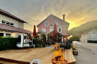 Cabane en bois enneigée avec un feu allumé à l'intérieur, vue de nuit dans un paysage hivernal.