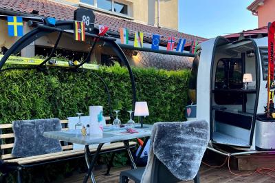 Cabane en bois enneigée avec un feu allumé à l'intérieur, vue de nuit dans un paysage hivernal.