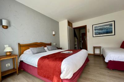Cabane en bois enneigée avec un feu allumé à l'intérieur, vue de nuit dans un paysage hivernal.