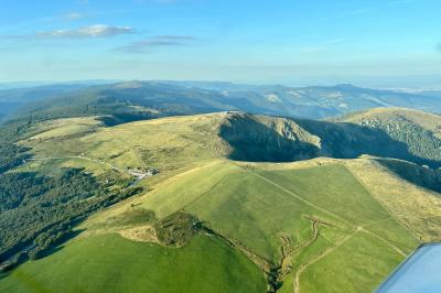 Cabane en bois enneigée avec un feu allumé à l'intérieur, vue de nuit dans un paysage hivernal.
