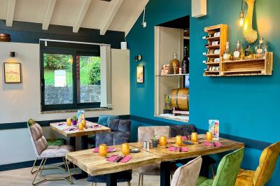 Chambre lumineuse avec un lit double, un lit simple, des tables de chevet et un tableau encadré au mur.