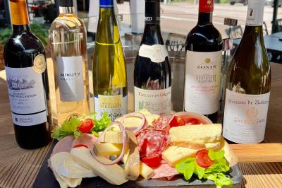 Chambre lumineuse avec un lit double, un lit simple, des tables de chevet et un tableau encadré au mur.