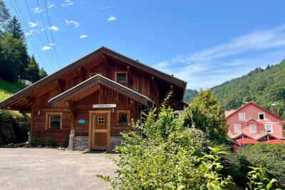Chambre lumineuse avec un lit double, un lit simple, des tables de chevet et un tableau encadré au mur.