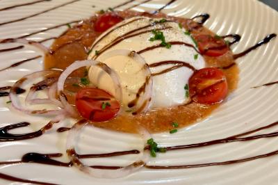 Chambre lumineuse avec un lit double, un lit simple, des tables de chevet et un tableau encadré au mur.