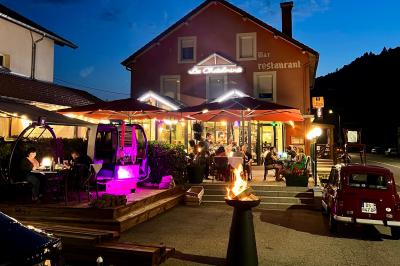 Chambre lumineuse avec un lit double, un lit simple, des tables de chevet et un tableau encadré au mur.