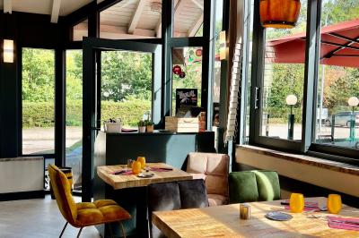 Chambre lumineuse avec un lit double, un lit simple, des tables de chevet et un tableau encadré au mur.
