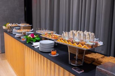 Assortiment de wraps garnis de légumes et de poulet, entourés de petits pains et de sandwichs sur un plateau.