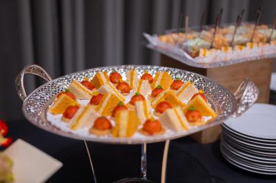 Assortiment de wraps garnis de légumes et de poulet, entourés de petits pains et de sandwichs sur un plateau.