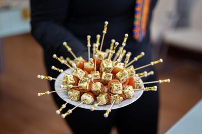 Assortiment de wraps garnis de légumes et de poulet, entourés de petits pains et de sandwichs sur un plateau.