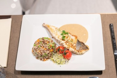 Assortiment de wraps garnis de légumes et de poulet, entourés de petits pains et de sandwichs sur un plateau.