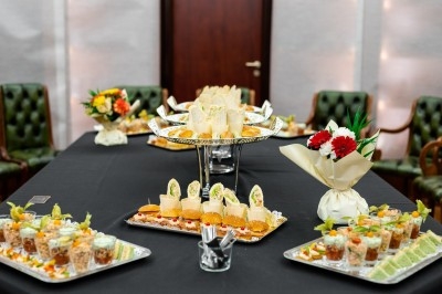 Assortiment de wraps garnis de légumes et de poulet, entourés de petits pains et de sandwichs sur un plateau.