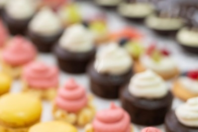 Assortiment de wraps garnis de légumes et de poulet, entourés de petits pains et de sandwichs sur un plateau.