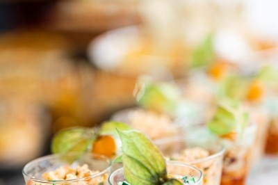 Assortiment de wraps garnis de légumes et de poulet, entourés de petits pains et de sandwichs sur un plateau.