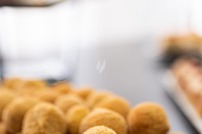 Assortiment de wraps garnis de légumes et de poulet, entourés de petits pains et de sandwichs sur un plateau.