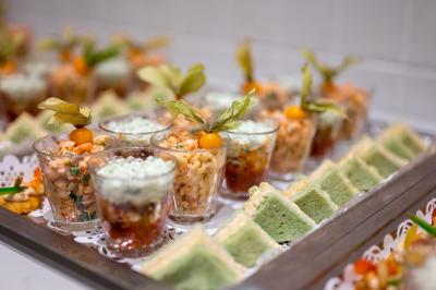 Assortiment de wraps garnis de légumes et de poulet, entourés de petits pains et de sandwichs sur un plateau.