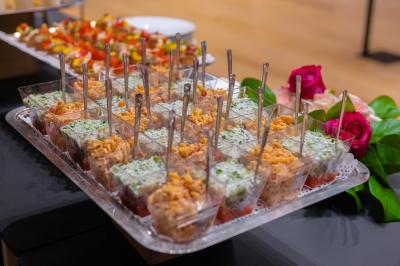 Assortiment de wraps garnis de légumes et de poulet, entourés de petits pains et de sandwichs sur un plateau.