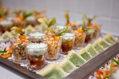 Assortiment de wraps garnis de légumes et de poulet, entourés de petits pains et de sandwichs sur un plateau.