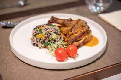 Assortiment de wraps garnis de légumes et de poulet, entourés de petits pains et de sandwichs sur un plateau.