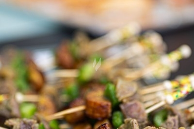 Assortiment de wraps garnis de légumes et de poulet, entourés de petits pains et de sandwichs sur un plateau.