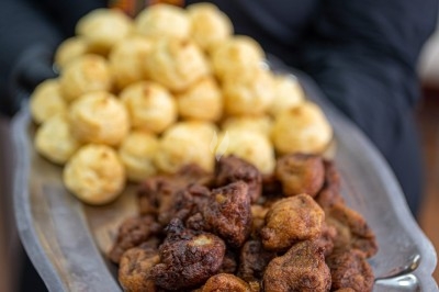 Assortiment de wraps garnis de légumes et de poulet, entourés de petits pains et de sandwichs sur un plateau.