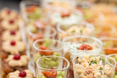 Assortiment de wraps garnis de légumes et de poulet, entourés de petits pains et de sandwichs sur un plateau.