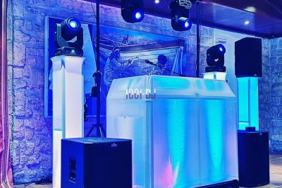 Un couple de mariés danse au milieu d'effets de fumée et d'étincelles dans une salle de réception décorée.