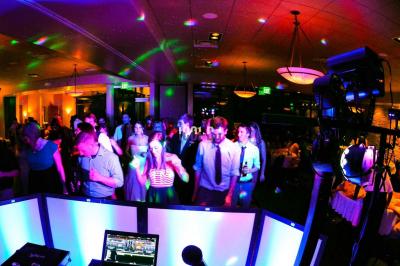 Un couple de mariés danse au milieu d'effets de fumée et d'étincelles dans une salle de réception décorée.