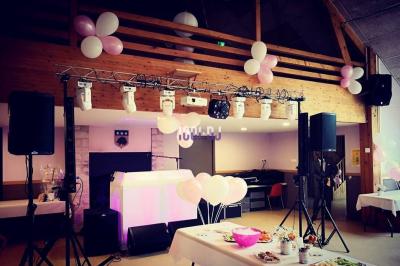 Un couple de mariés danse au milieu d'effets de fumée et d'étincelles dans une salle de réception décorée.