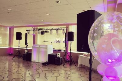 Un couple de mariés danse au milieu d'effets de fumée et d'étincelles dans une salle de réception décorée.